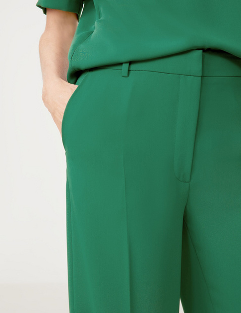 Flowing trousers with pressed pleats