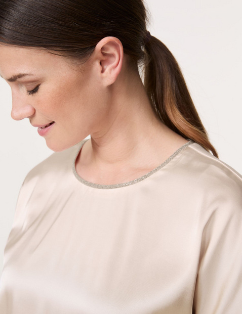 Blouse top with a glittering neckline trim