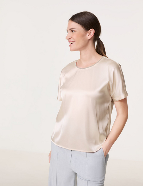 Blouse top with a glittering neckline trim